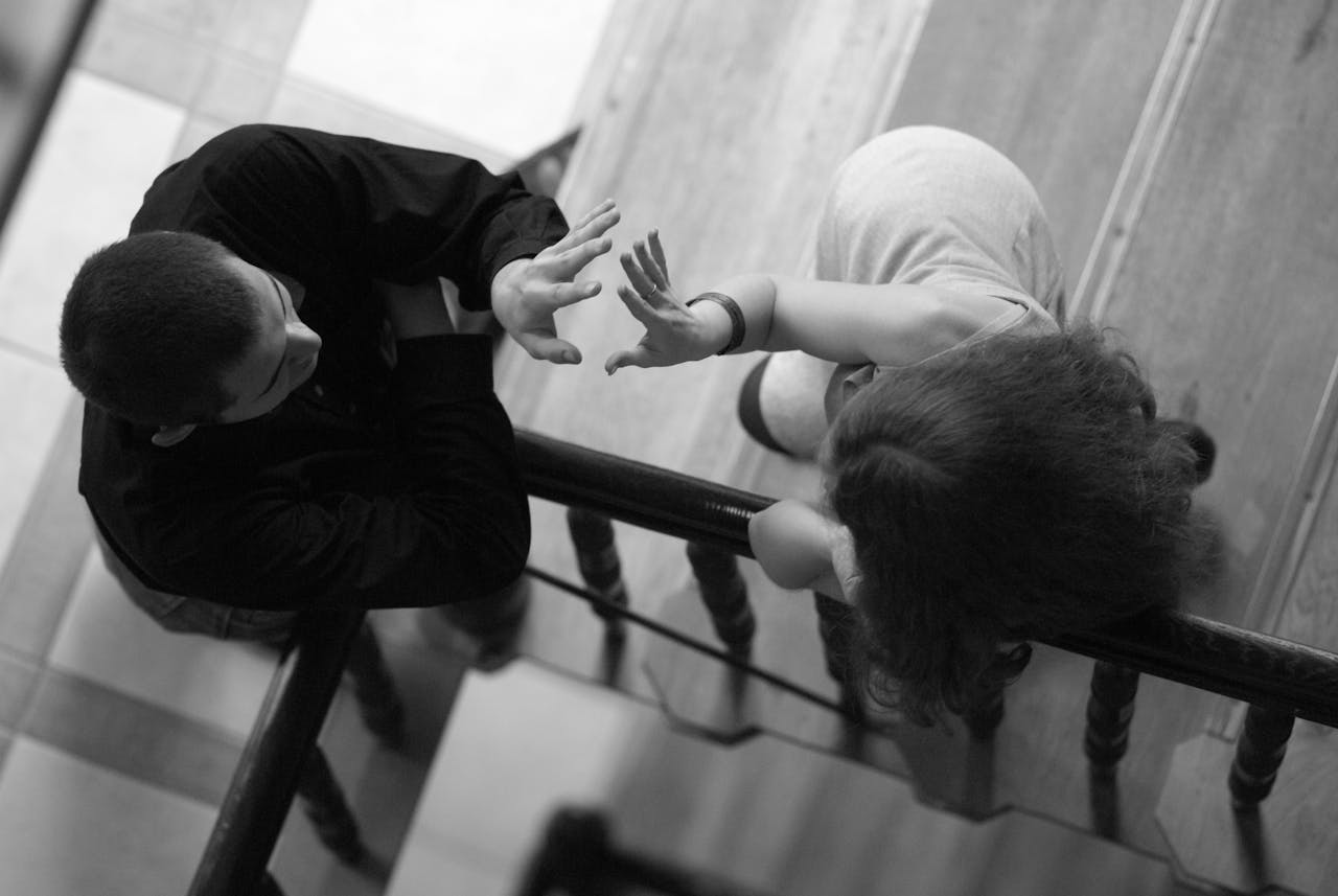 A man and child interact on a staircase, captured in monochrome in Wrocław, Poland.
