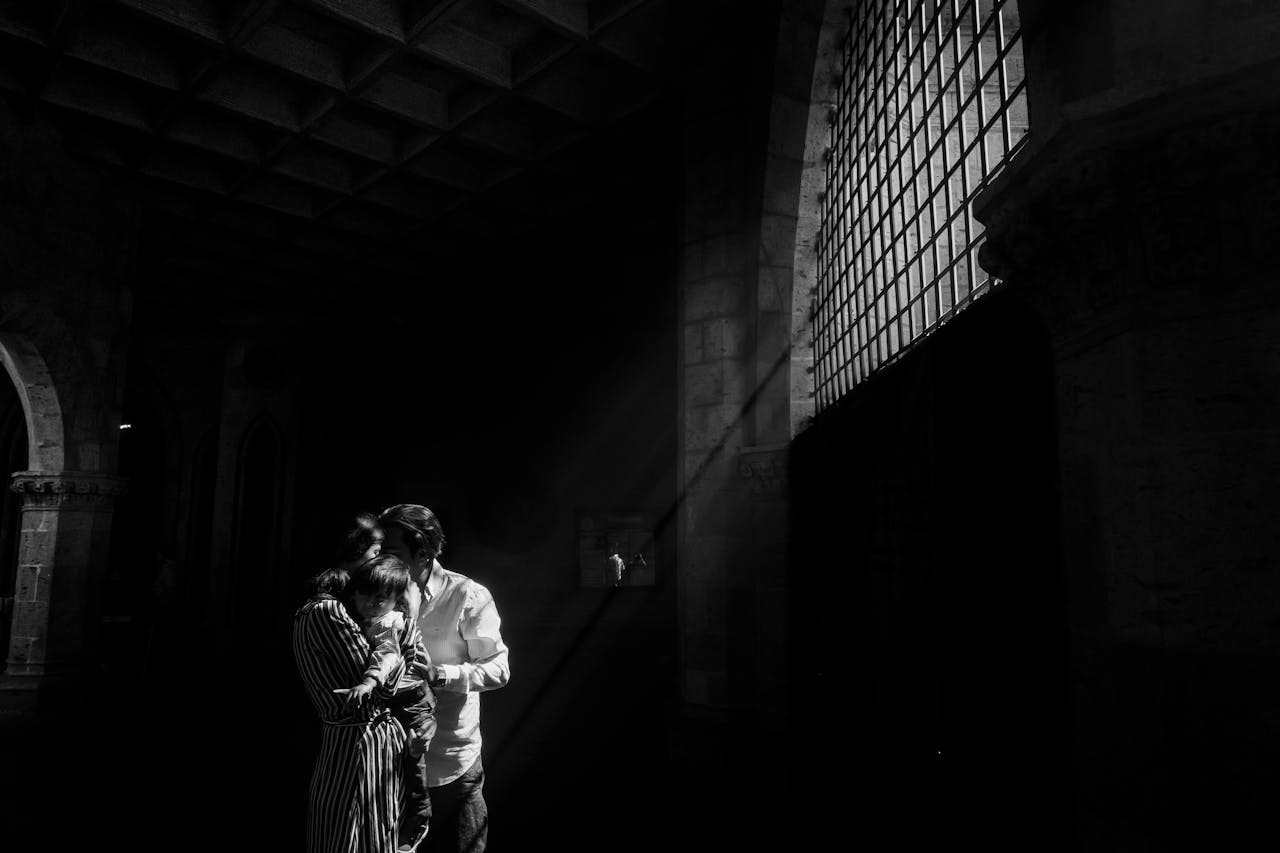 A tender family moment in dramatic black and white lighting, capturing love and connection.